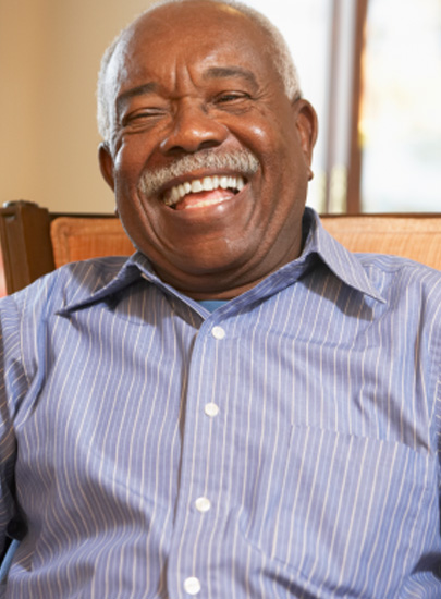 Senior man sitting in wooden chair smiling