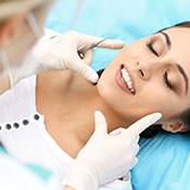 Dentist examining woman’s smile