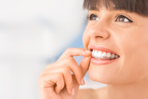 Woman inserting Invisalign in Chula Vista